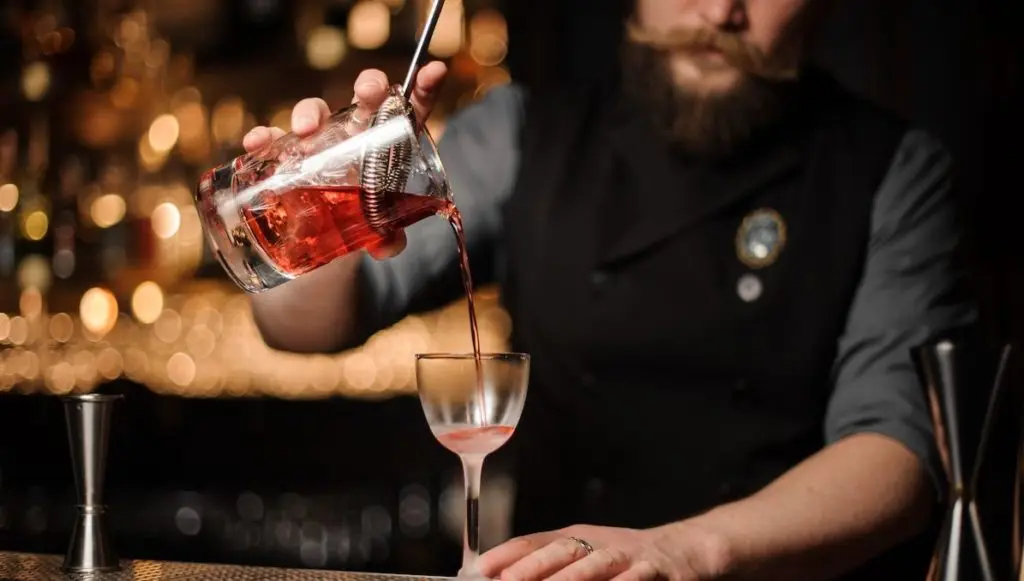 Bartenders uses Hawthorne Strainer to make cocktail