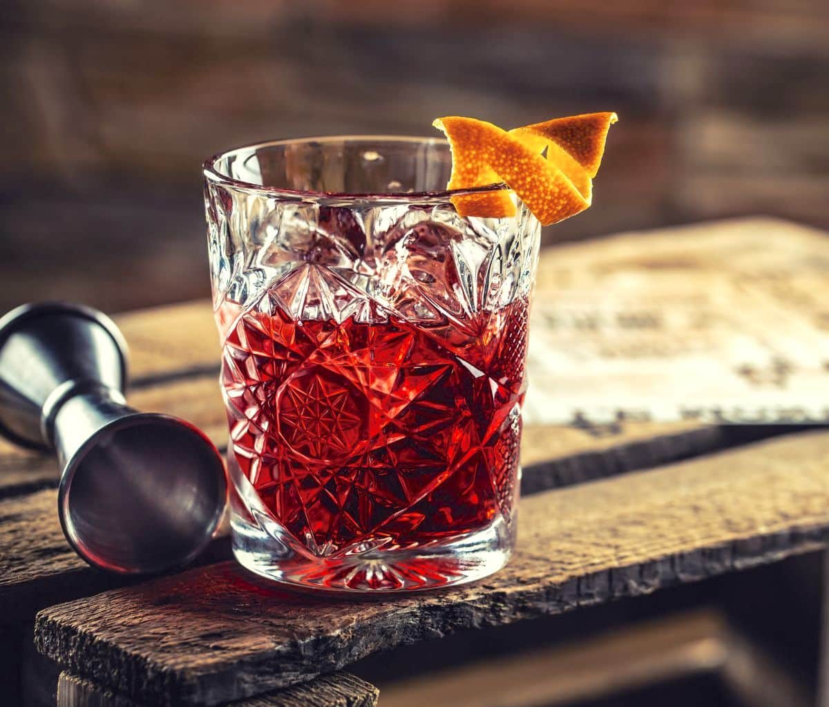 Negroni Cocktail served with orange peel next to Jigger