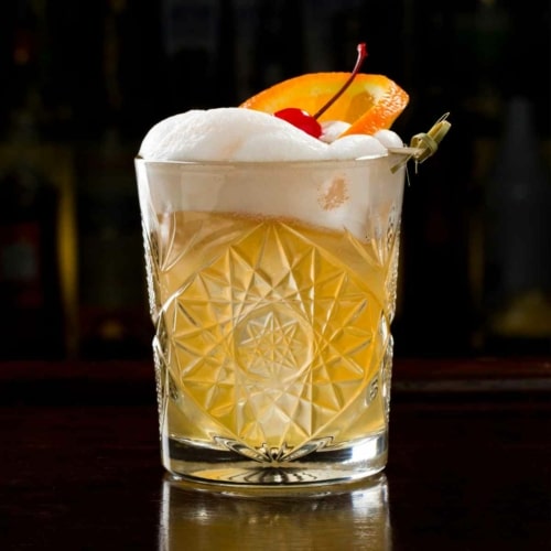 Rum Sour cocktail garnished with orange peel