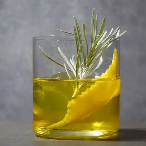 White Negroni Cocktail with lemon peel and Rosemary