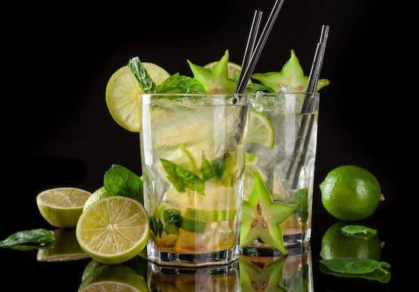 Two Mojito cocktails on dark background