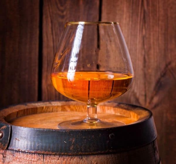 Bourbon in snifter glass on barrel