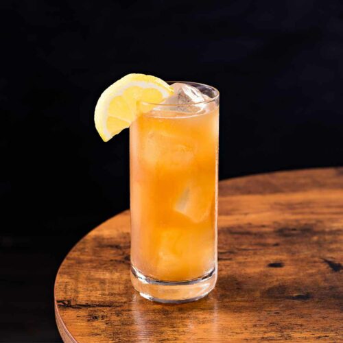 Long Island Iced Tea drink on wood table with black background