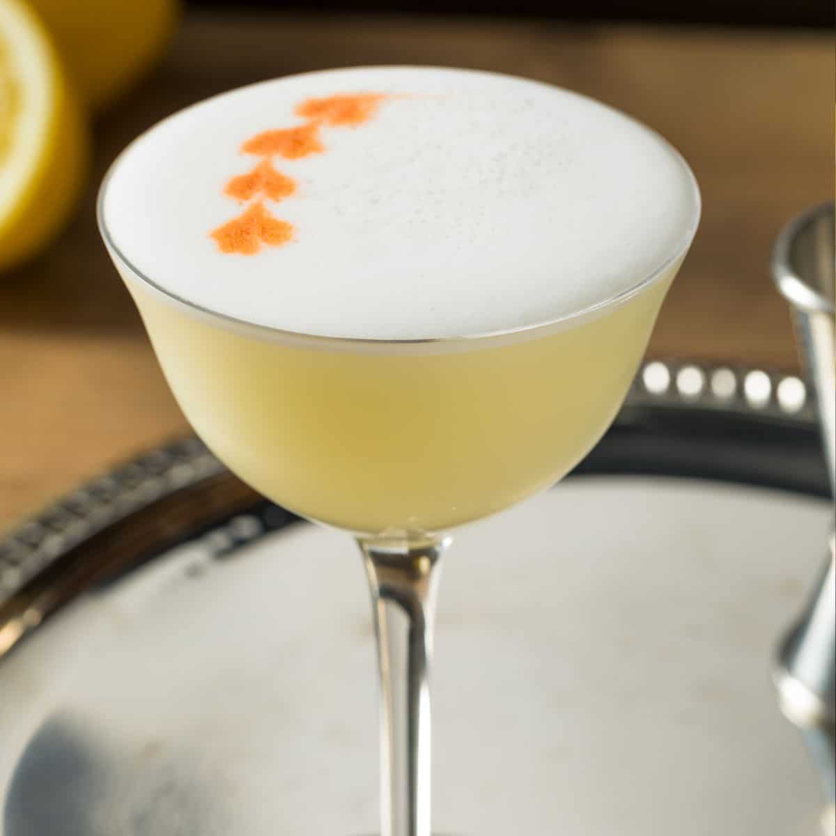 Pisco Sour Cocktail with Angostura Bitters on silver tablet
