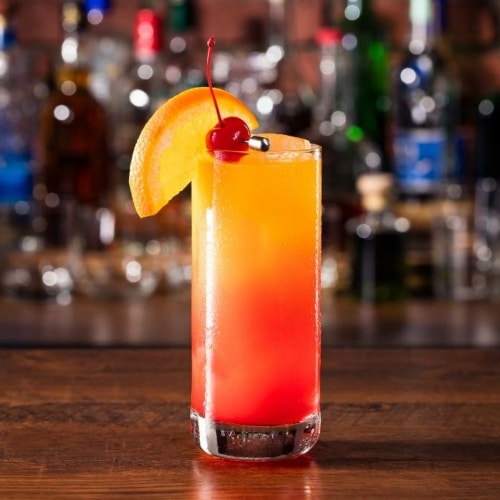 Tequila Sunrise Cocktail with orange wedge and cherry