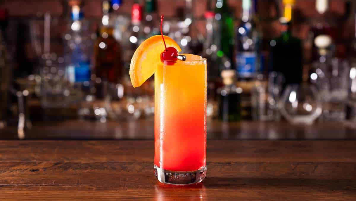 Tequila Sunrise Cocktail with orange wedge and cherry