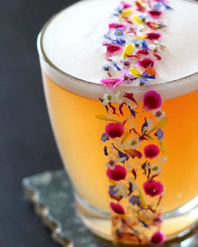Cocktail garnished with flowers and petals
