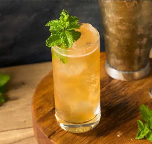 Suffering Bastard Cocktail garnished with mint on wooden board 