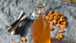Orgeat syrup in bottle and almonds