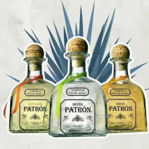 Different Patron Tequila bottles in front of blue weber agave