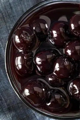 dark red Maraschino Cherries with syrup in bowl