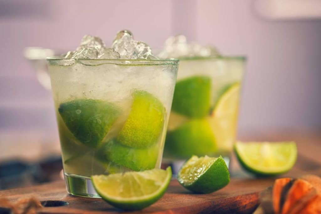 Caipiroska cocktail with fresh limes on table