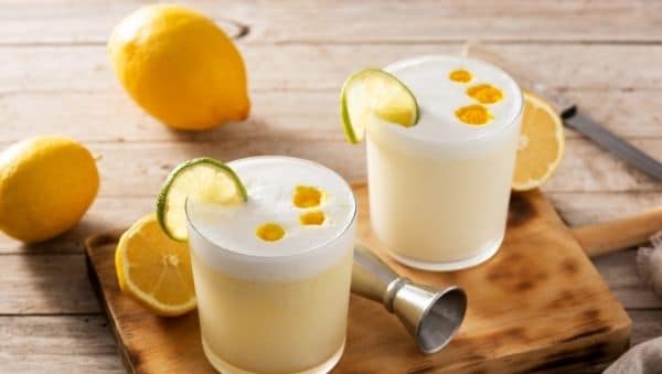 Two Pisco Sour cocktails with lemons