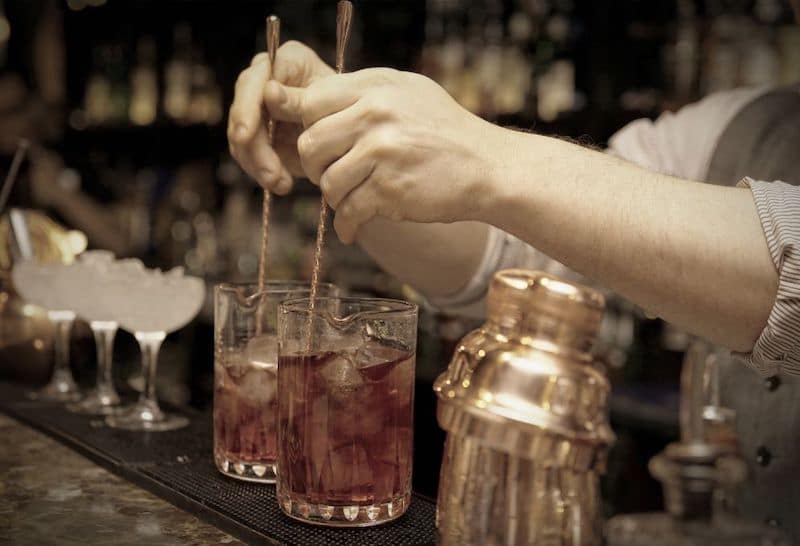 Bartender stirring Scotch Old Fashioned cocktails