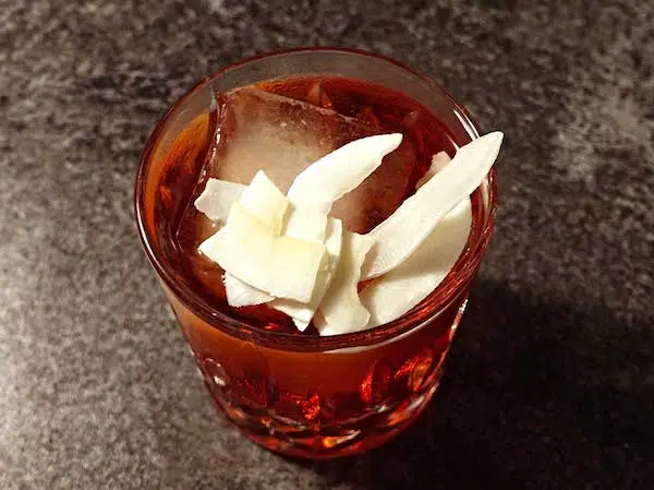 Coconut Negroni cocktail with dried coconut chips
