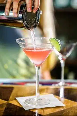 Cosmopolitan cocktail being poured on table