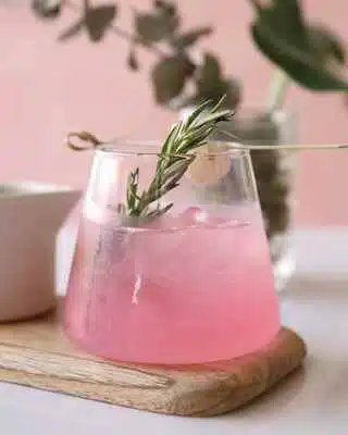 Pink Empress Gin Sour cocktail with rosemary garnish