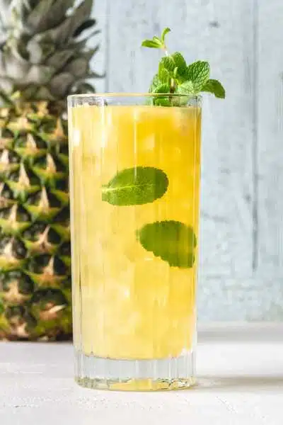 Spiced Pineapple Mojito cocktail with pineapple in background