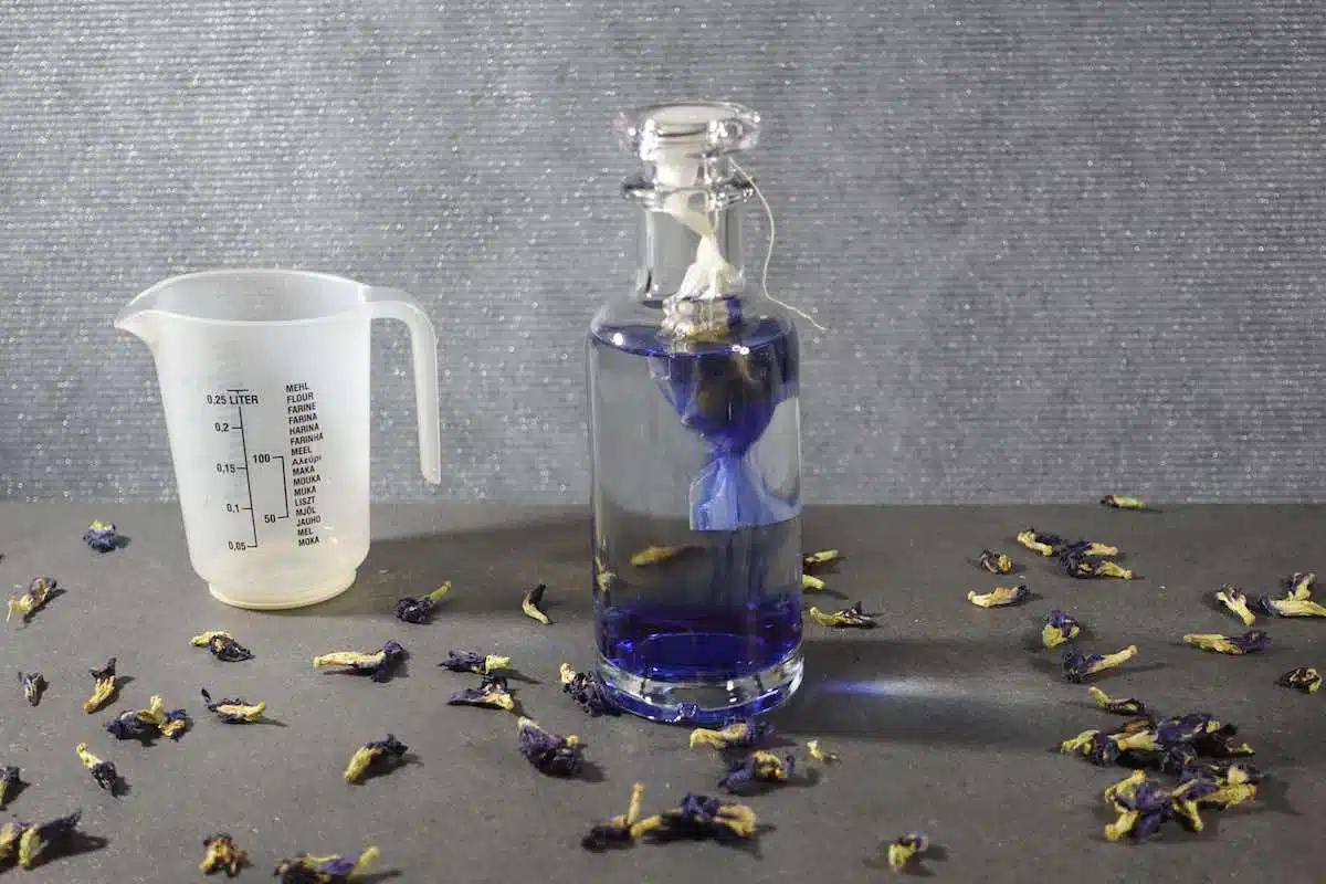 Gin in bottle and butterfly pea flowers in tea bag