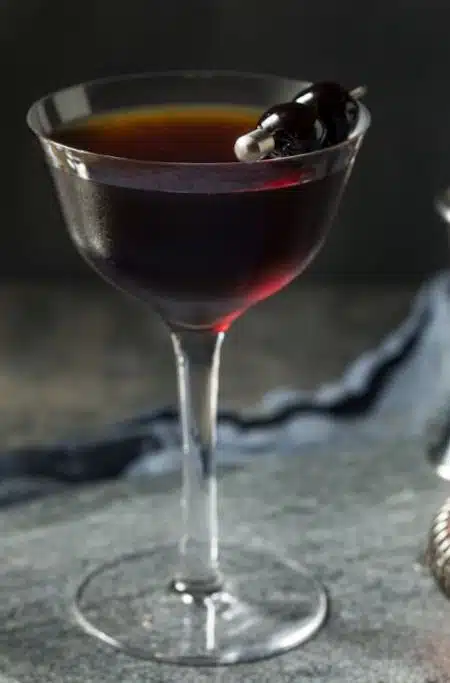 Black Manhattan Cocktail with Maraschino cherries on pick